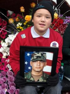 Twelve-year-old Ernesto Bravo Chavez, an organ donor recipient, holds up a photo of U.S. veteran Gabriel Barajas, who lost his life in an automobile accident. Photo Credit: Dennis J. Freeman
