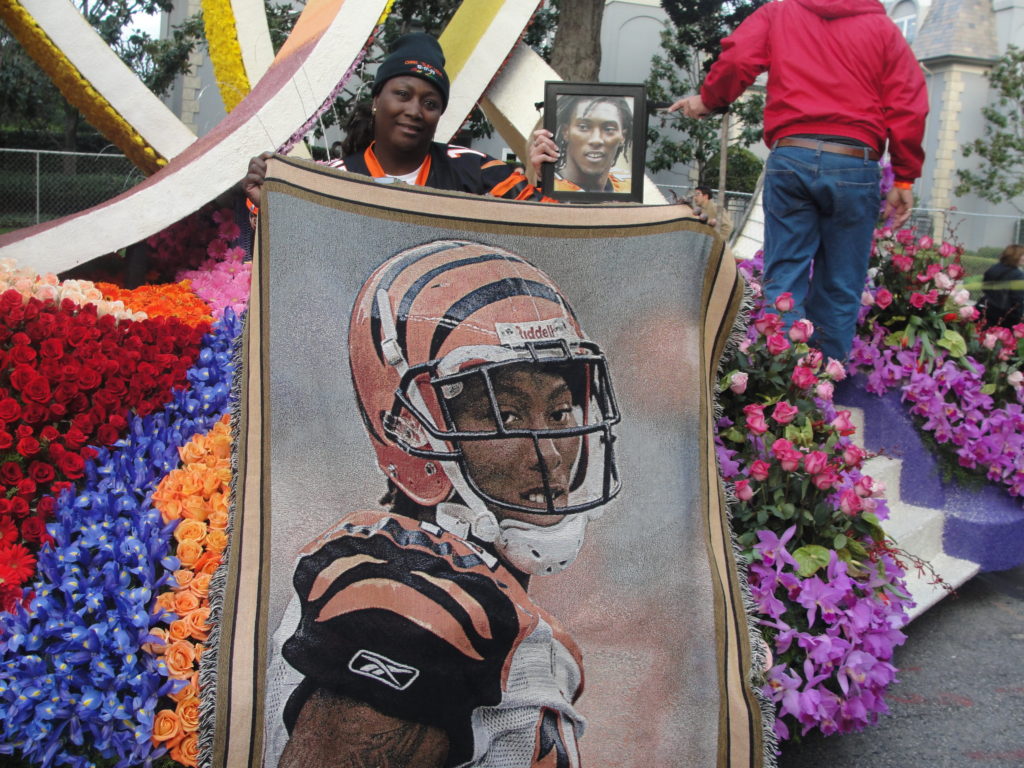 Carolyn Henry  Glaspy holds up a artistic likeness of  her son, former NFL player Chris Henry at the 2013 Tournament of Roses Parade. Henry, who died after falling from a truck, had his organs donated. Photo Credit: Dennis J. Freeman