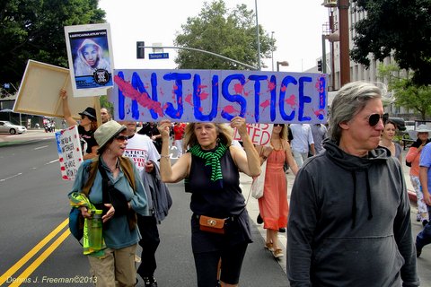 Demonstrators walk through downtown Los Angeles calling on the federal government to bring charges against George Zimmerman. Photo: Dennis J. Freeman
