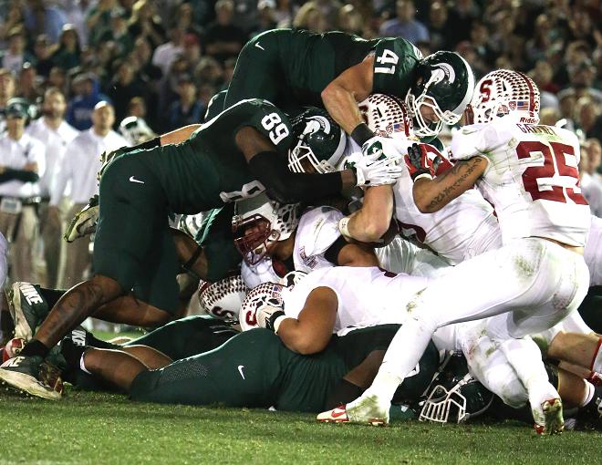 Play of the game: Michigan State lineback Kyler Elsworth goes airborne to stuff Ryan Hewitt of Stanford. Photo Credit: Jevone Moore/Full Image 360