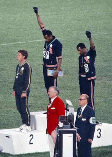 American sprinters Tommie Smith,John Carlos and Peter Norman during the award ceremony of the 200 m race at the Mexican Olympic games. During the awards ceremony, Smith and Carlos protested against racial discrimination: they went barefoot on the podium and listened to their anthem bowing their heads and raising a fist with a black glove. Mexico City, Mexico, 1968 Mexico city, Mexico, 1968. 