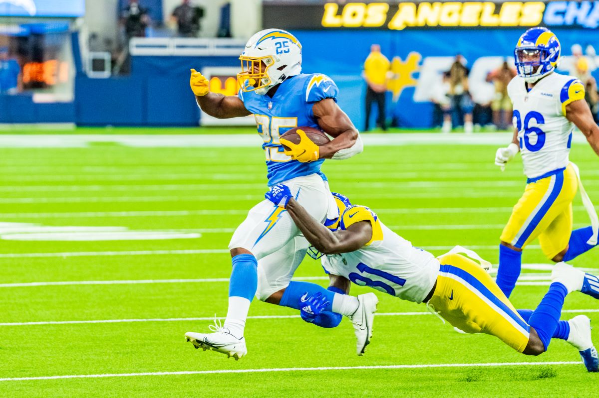 Los Angeles Chargers running back Isaiah Spiller tries to avoid